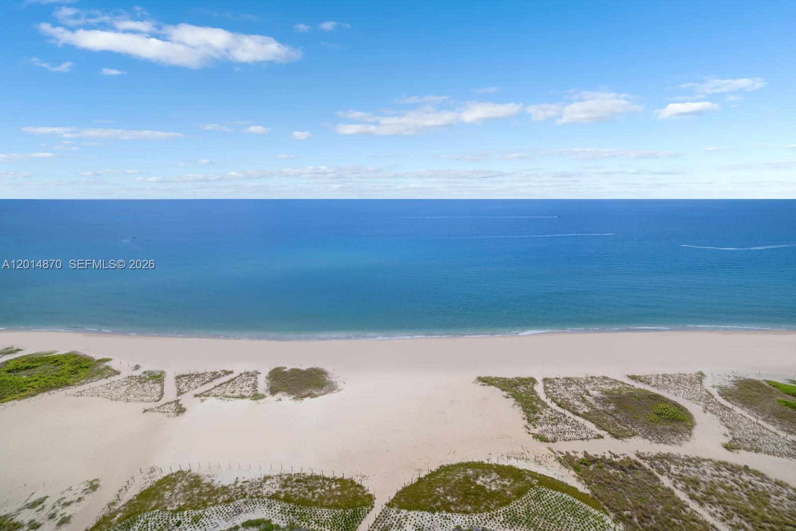 An aerial view shows a sandy beach with dunes and vegetation meeting the ocean — 900 N Ocean Blvd # 1903, Pompano Beach FL 33062, POMPANO BEACH, FL