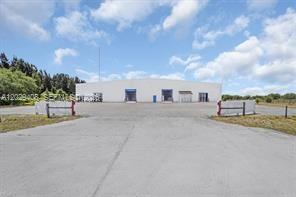 A wide, single-story warehouse building with multiple loading bays sits behind a paved lot — 14961 W State Road 78, Moore Haven FL 33471, MOORE HAVEN, FL