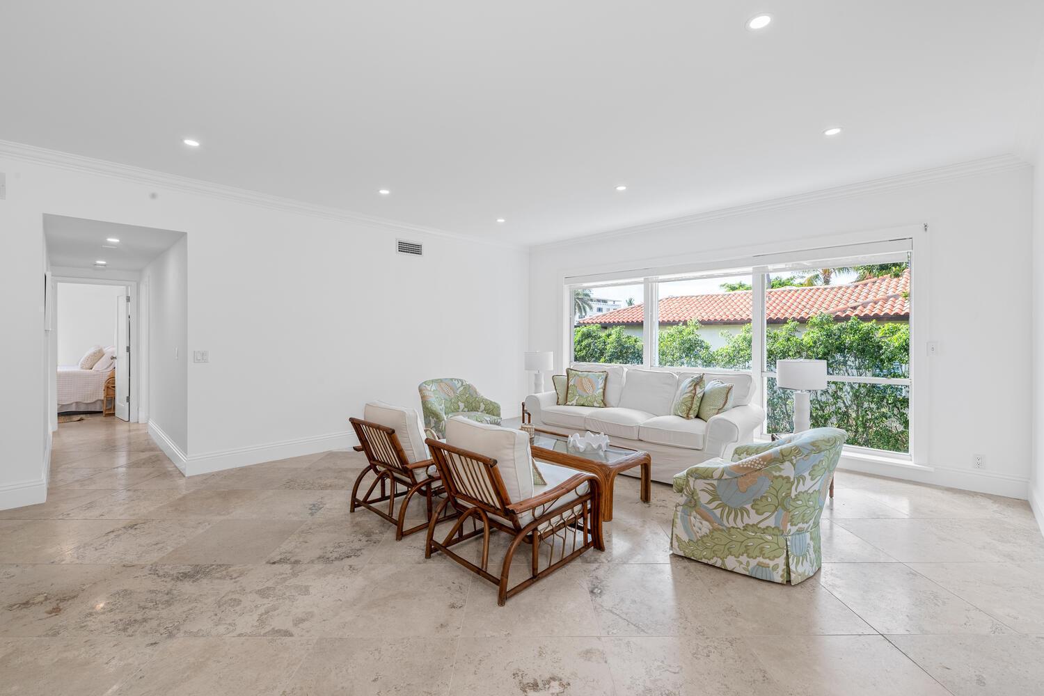 A living room with tile floors, white walls, and a seating area facing a large window — 350 Cocoanut Row # 3a, Palm Beach FL 33480, PALM BEACH, FL