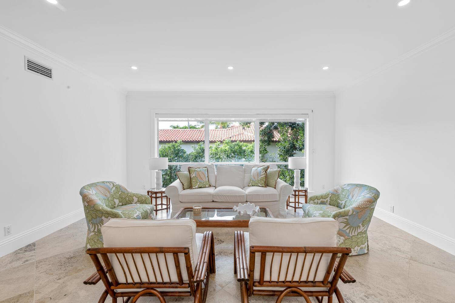 A bright living room features a white sofa, patterned armchairs, and bamboo chairs on tile flooring — 350 Cocoanut Row # 3a, Palm Beach FL 33480, PALM BEACH, FL