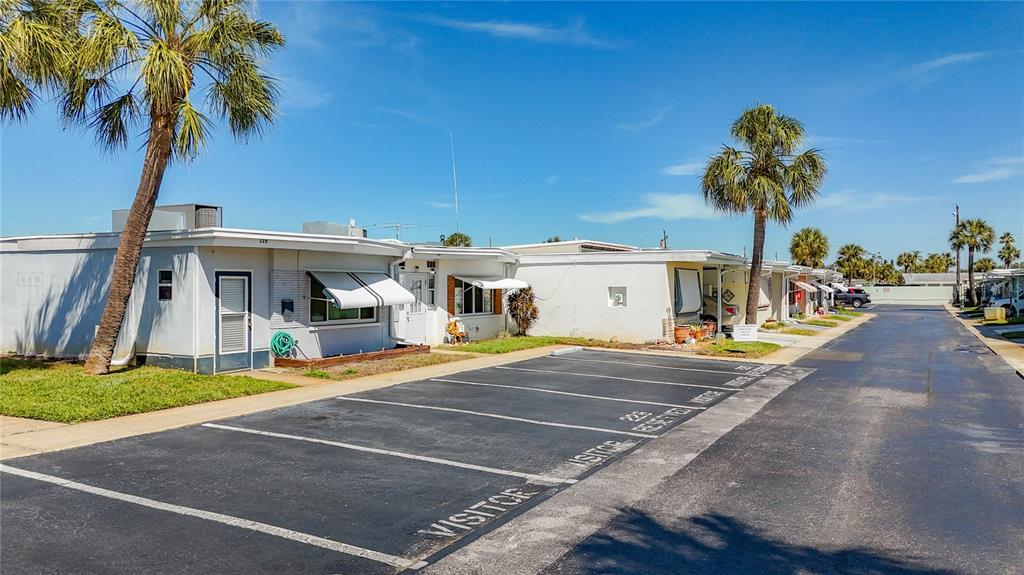 A row of single-story mobile homes sits beside a paved parking lot with visitor spaces — 250 ROSERY ROAD NW UNIT 228, LARGO, FL