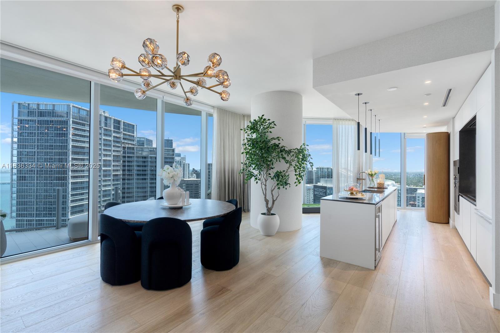 A modern dining area and kitchen feature floor-to-ceiling windows, light wood floors, and city views — 300 Biscayne Blvd way # 4707, Miami FL 33131, MIAMI, FL