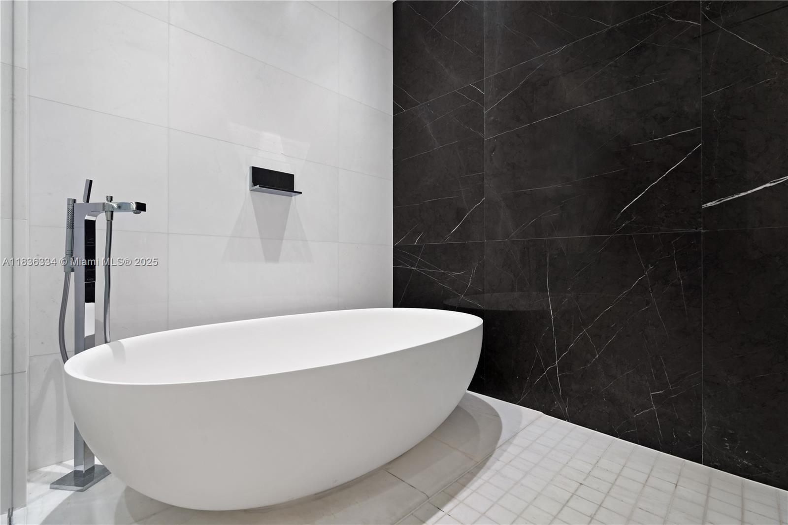 A modern bathroom features a white freestanding tub against contrasting white and black marble walls — 300 Biscayne Blvd way # 4707, Miami FL 33131, MIAMI, FL