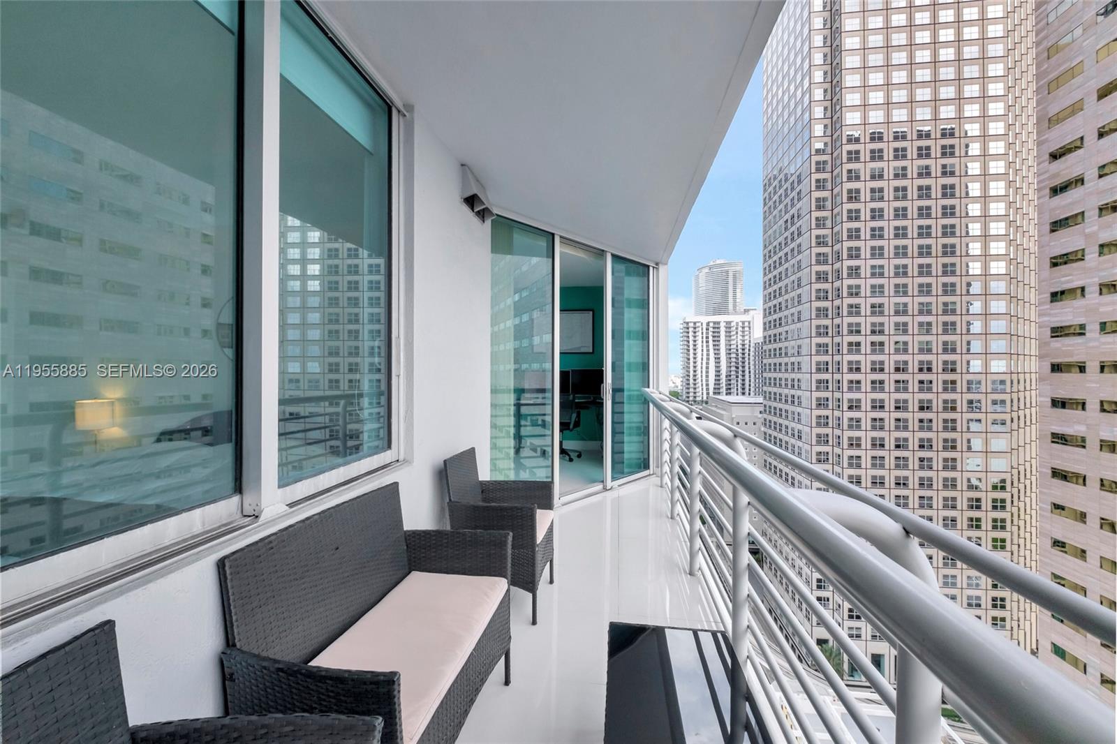A balcony with outdoor furniture overlooks a dense urban skyline of high-rise buildings — 325 S Biscayne Blvd # 2616, Miami FL 33131, MIAMI, FL