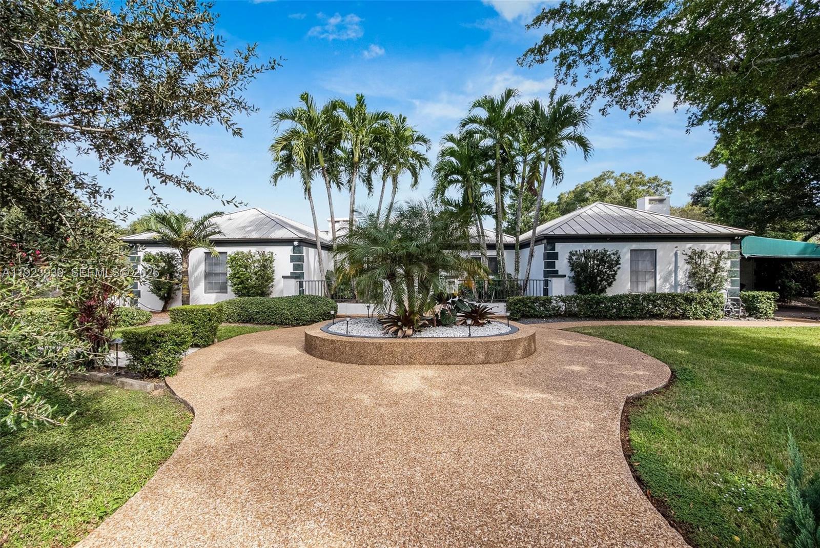 A single-story house with a white exterior, metal roof, and a circular pebble driveway — 11155 SW 40th St, Davie FL 33328, DAVIE, FL