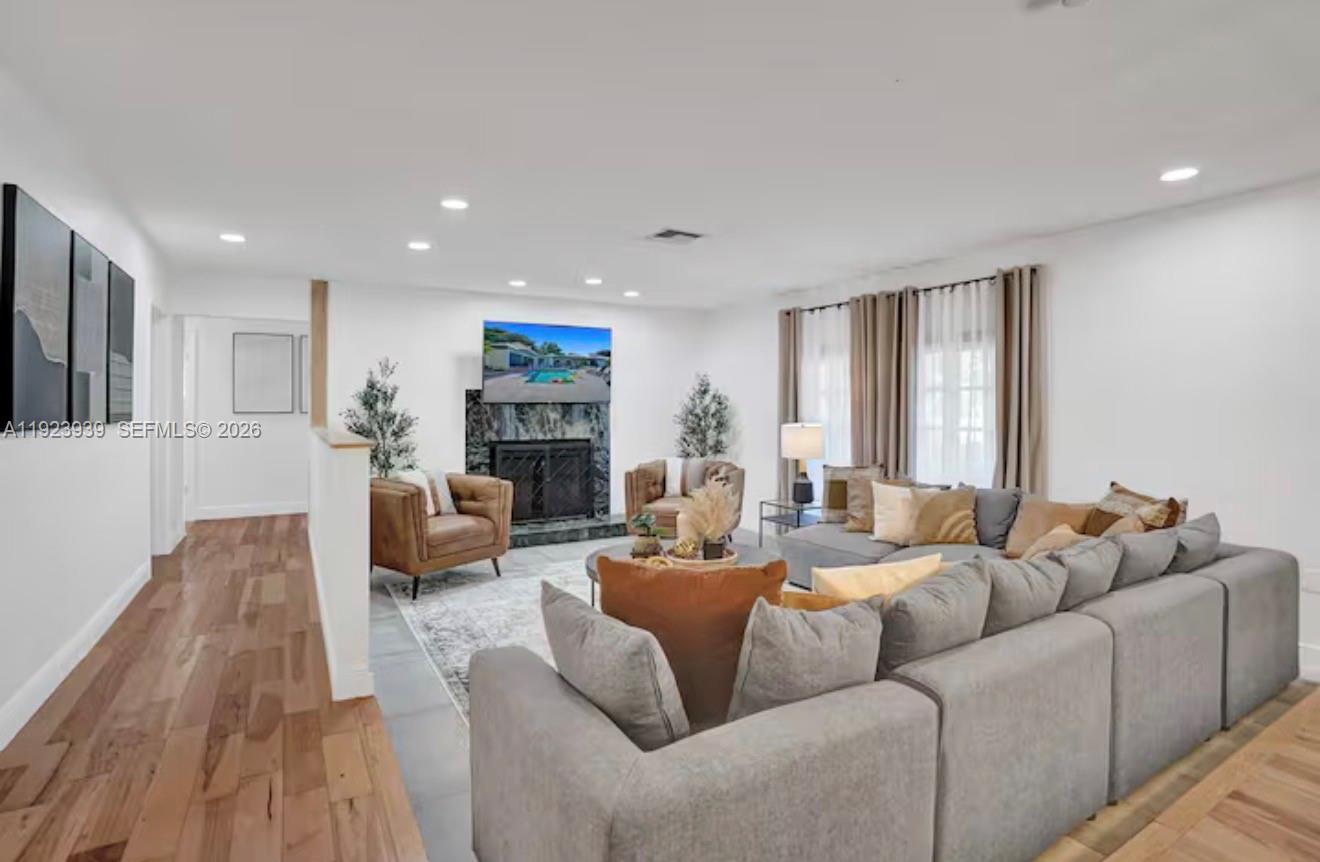 A living room features a fireplace, a large sectional sofa, and light wood flooring — 11155 SW 40th St, Davie FL 33328, DAVIE, FL