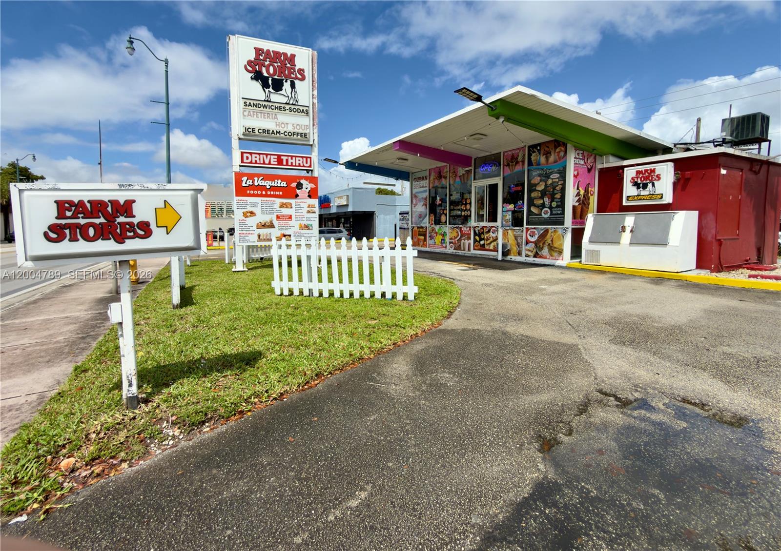 A Farm Stores drive-thru building features a white picket fence and a large menu sign — FARM STORE CORAL GABLES, Miami FL 33134, MIAMI, FL