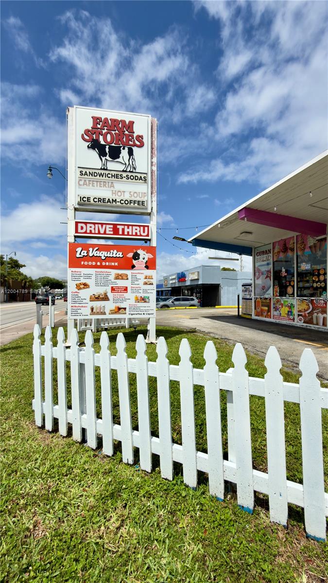 A white picket fence stands in front of a Farm Stores drive-thru building — FARM STORE CORAL GABLES, Miami FL 33134, MIAMI, FL