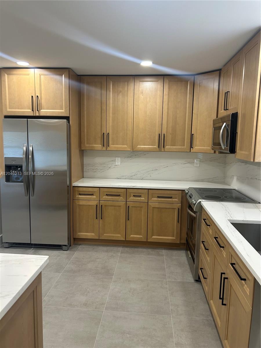 A kitchen features light wood cabinets, stainless steel appliances, and white marble-patterned countertops — 9723 SW 3rd St, Boca Raton FL 33428, BOCA RATON, FL