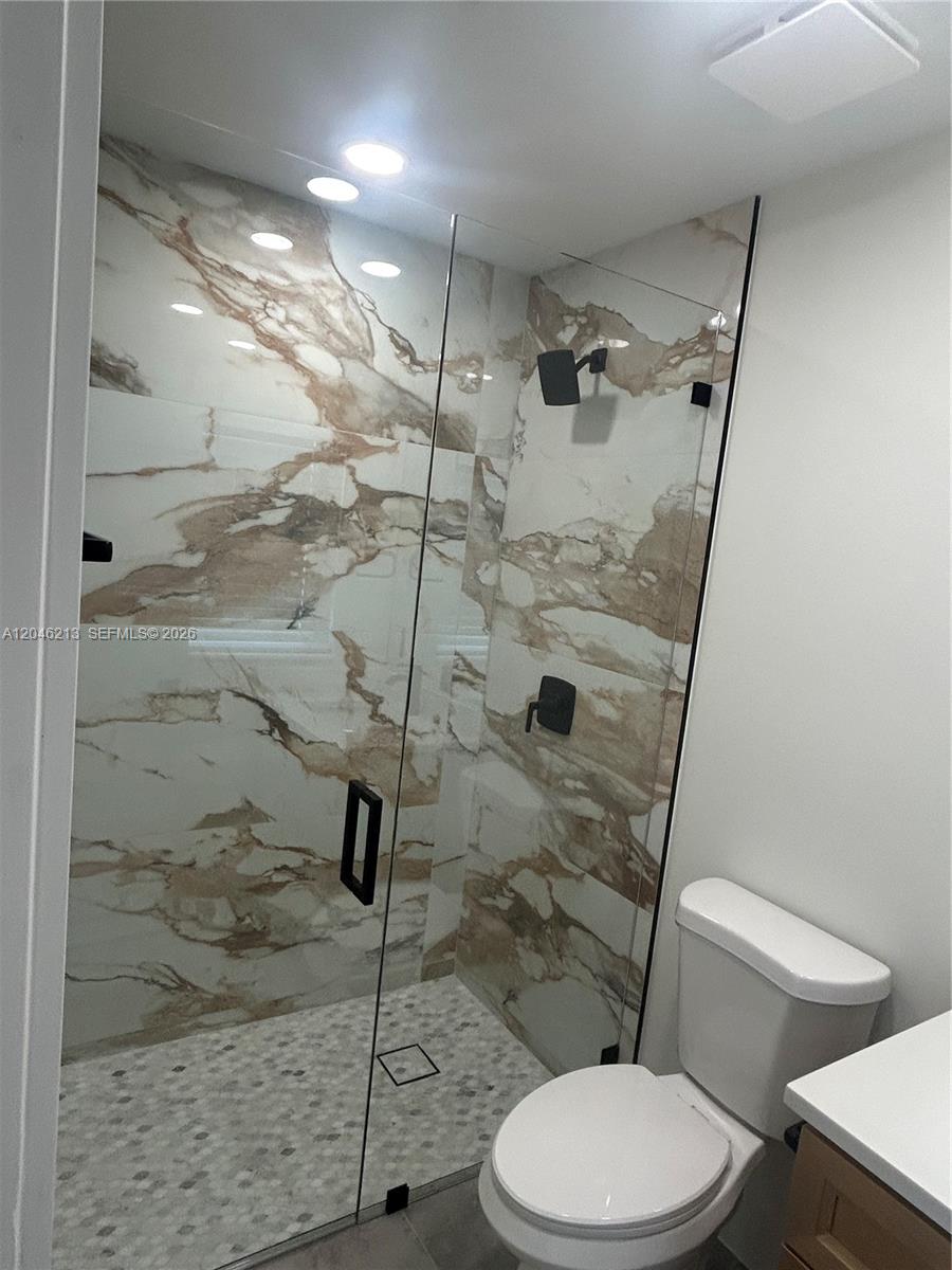 A bathroom features a glass-enclosed shower with marble-patterned tile walls and a pebble floor — 9723 SW 3rd St, Boca Raton FL 33428, BOCA RATON, FL