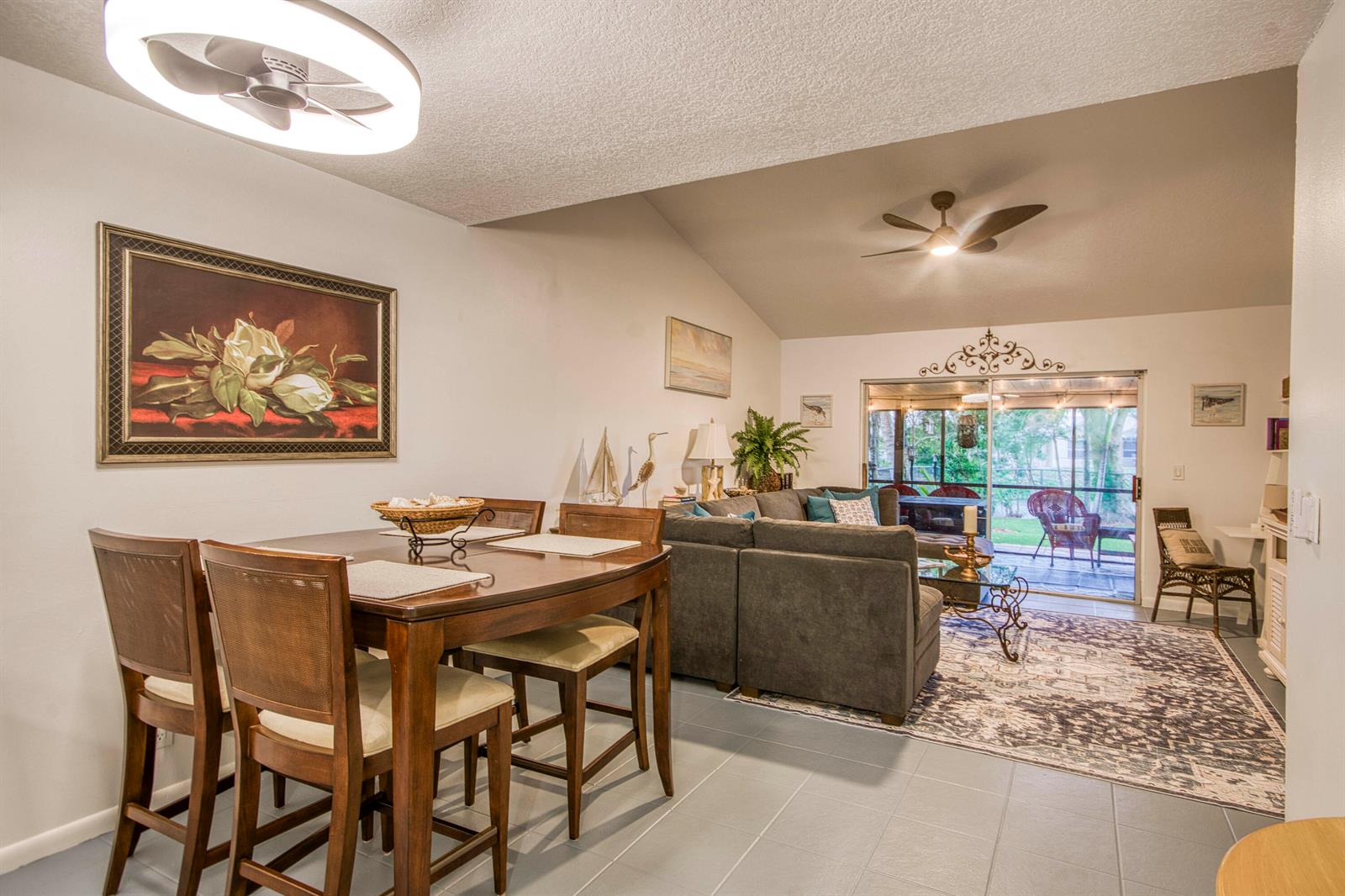 A dining area with a wooden table and chairs opens into a living room with tile floors — 178 Pinewood Court, Jupiter FL 33458, JUPITER, FL