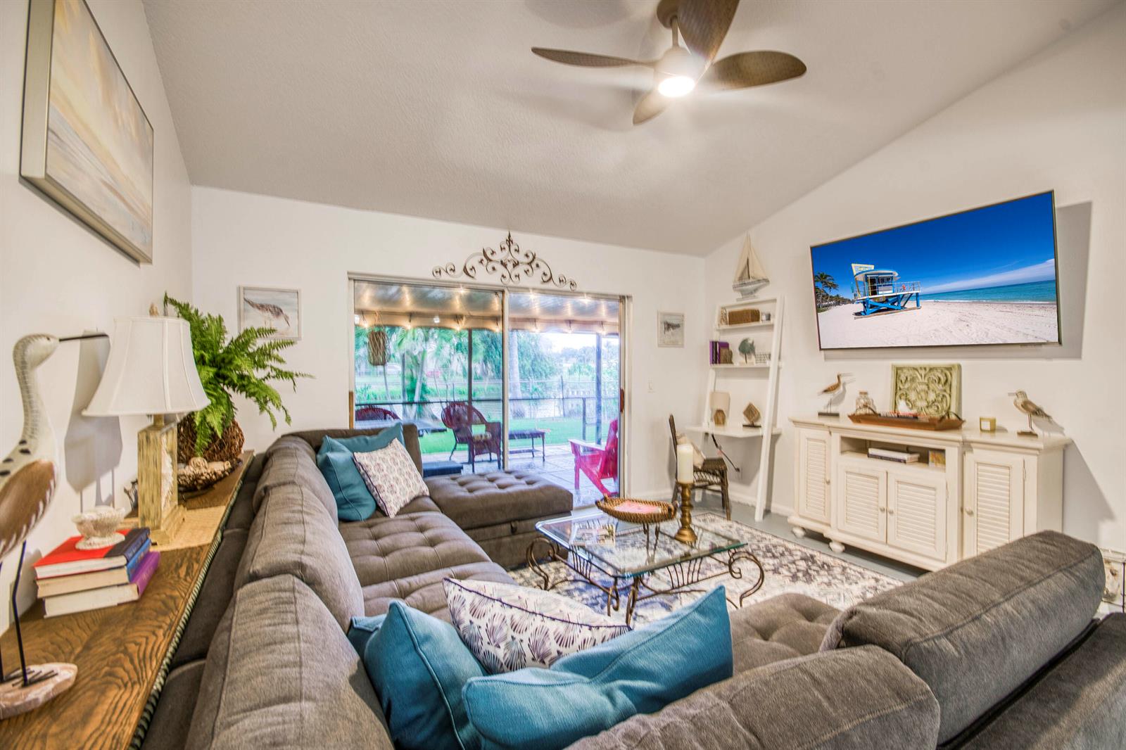A living room features a large gray sectional sofa, a glass coffee table, and a television — 178 Pinewood Court, Jupiter FL 33458, JUPITER, FL