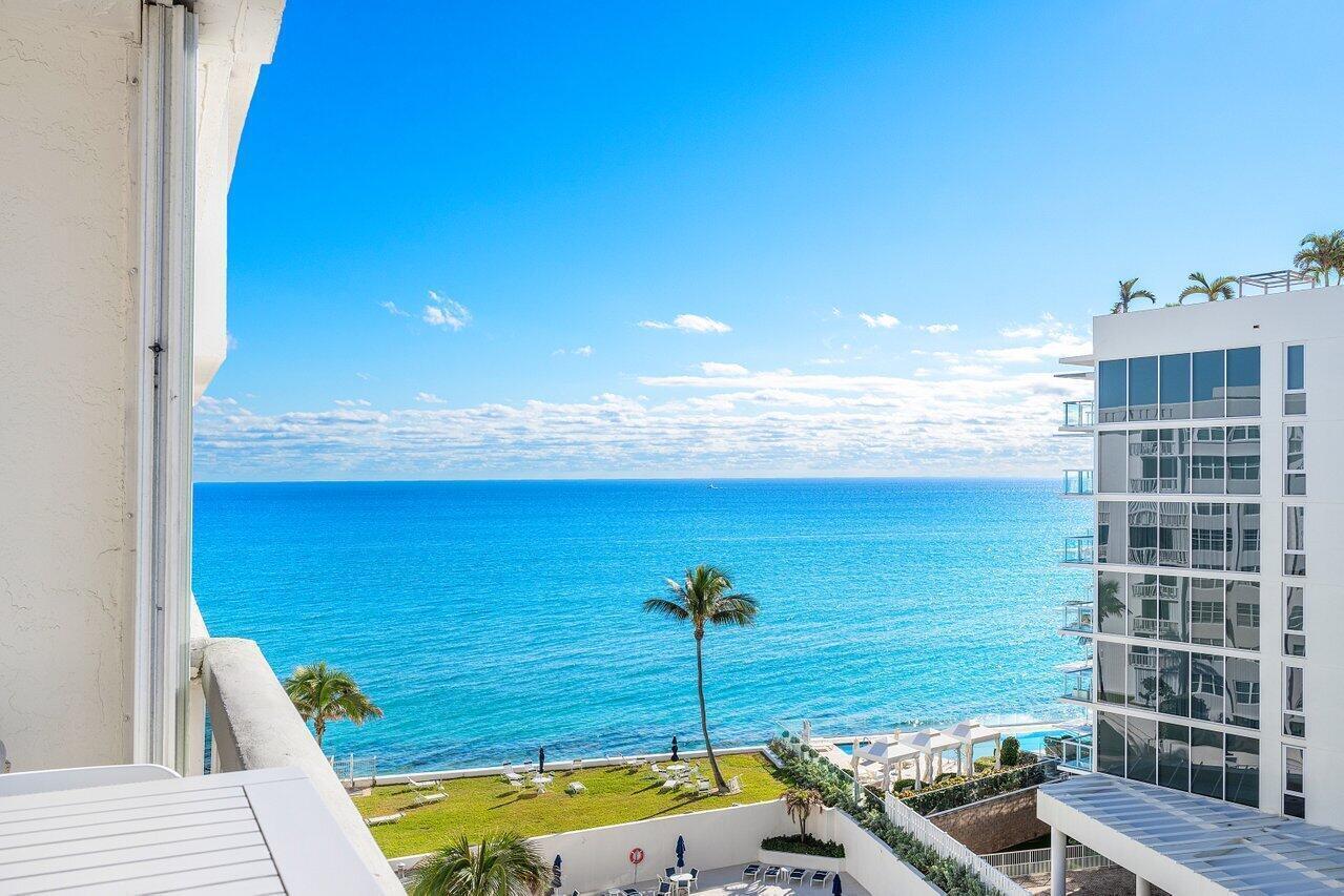 A balcony view overlooking a grassy lawn, a palm tree, and the blue ocean — 3570 S Ocean Boulevard # 806, Palm Beach FL 33480, PALM BEACH, FL