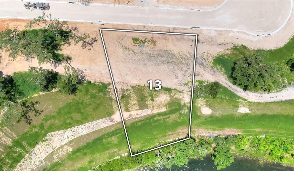An aerial view shows a vacant, trapezoidal residential lot labeled 13 bordering a paved road — 145 TRANQUIL MIRROR LAKE COURT Lot 13, CLERMONT, FL