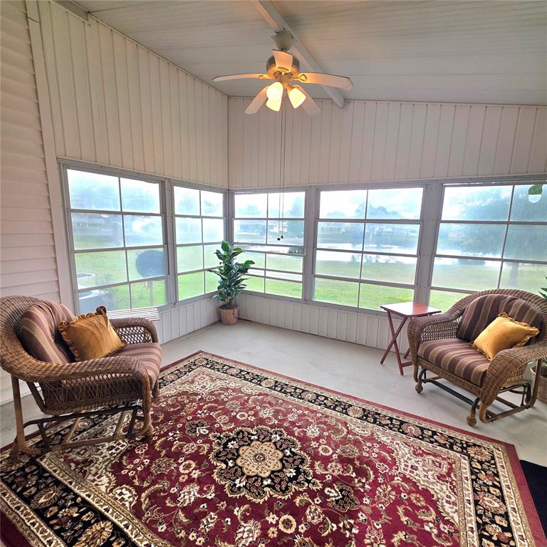A living room features a beige sofa, a recliner, a coffee table, and a sliding door — 6114 GRAND OAKS DRIVE SE, WINTER HAVEN, FL