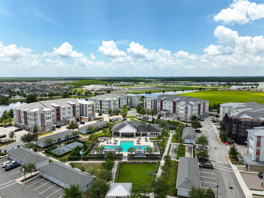 An aerial view shows a multi-story apartment complex with a central pool and parking areas — 7505 LAUREATE BLVD UNIT 2208, ORLANDO, FL