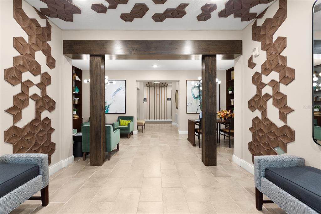 A lobby area features geometric wood wall accents, a dark wood beam, and tiled flooring — 7505 LAUREATE BLVD UNIT 2208, ORLANDO, FL