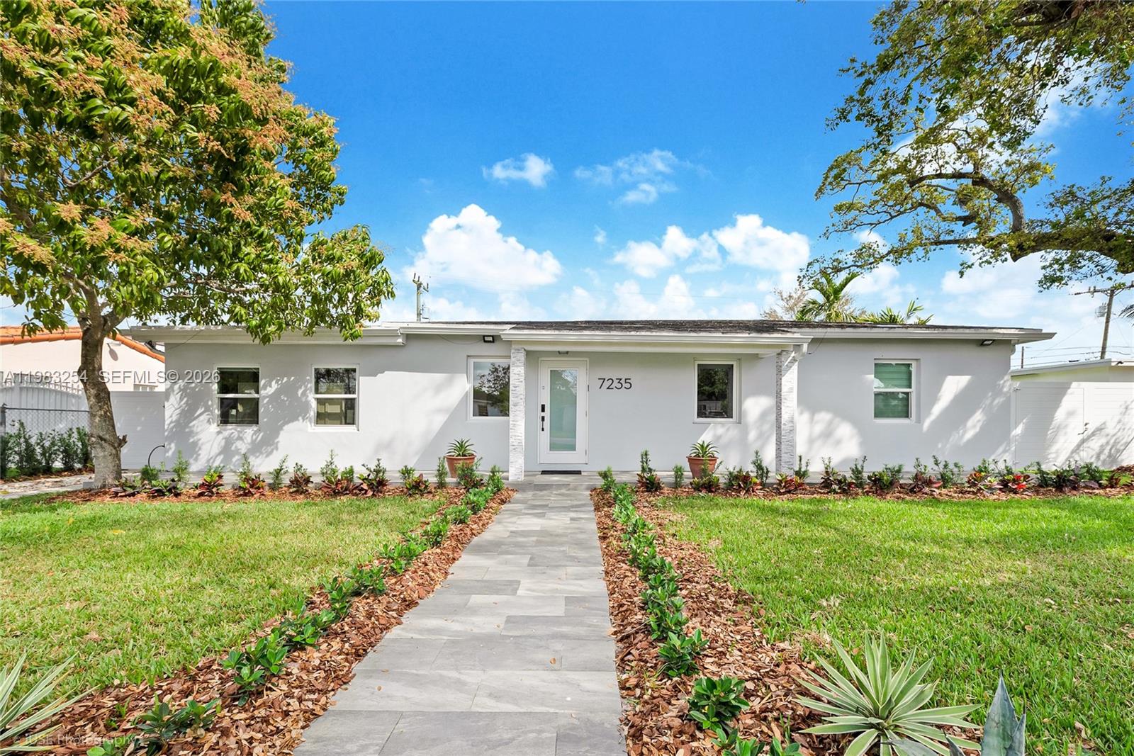 A single-story house with a gray exterior, a stone walkway, and a manicured lawn — 7235 SW 39th St, Miami FL 33155, MIAMI, FL