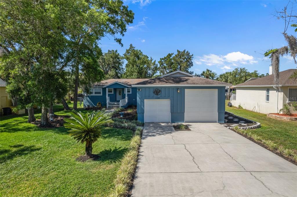 A blue single-story house features a two-car garage and a concrete driveway — 11430 W WATERWAY DRIVE, HOMOSASSA, FL