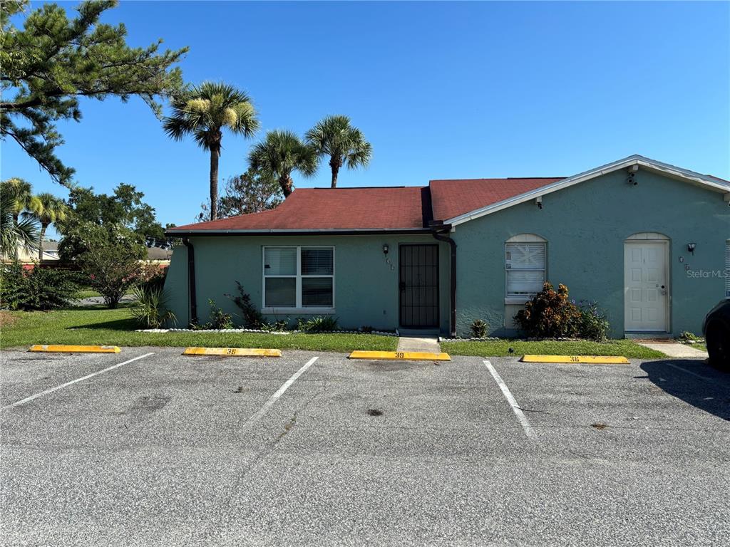 A teal, single-story residential building features a red roof and three designated parking spaces — 39 LAGO MESA WAY, KISSIMMEE, FL