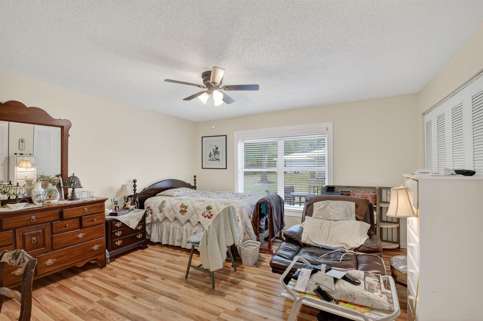 A bedroom features a wooden dresser, a bed with a floral quilt, and a recliner — 782 Nantucket Circle, FL 33467, FL