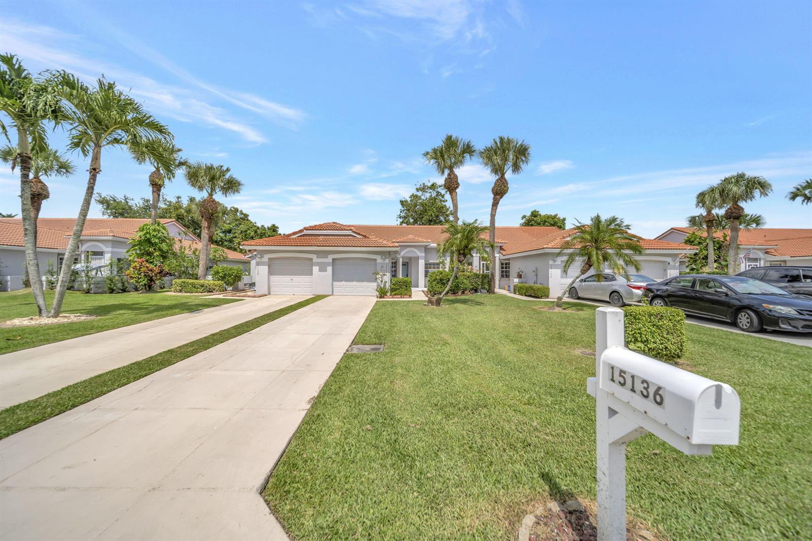 A single-story house with a two-car garage, tile roof, and palm trees in the yard — 15136 W Tranquility Lake Drive, Delray Beach FL 33446, DELRAY BEACH, FL