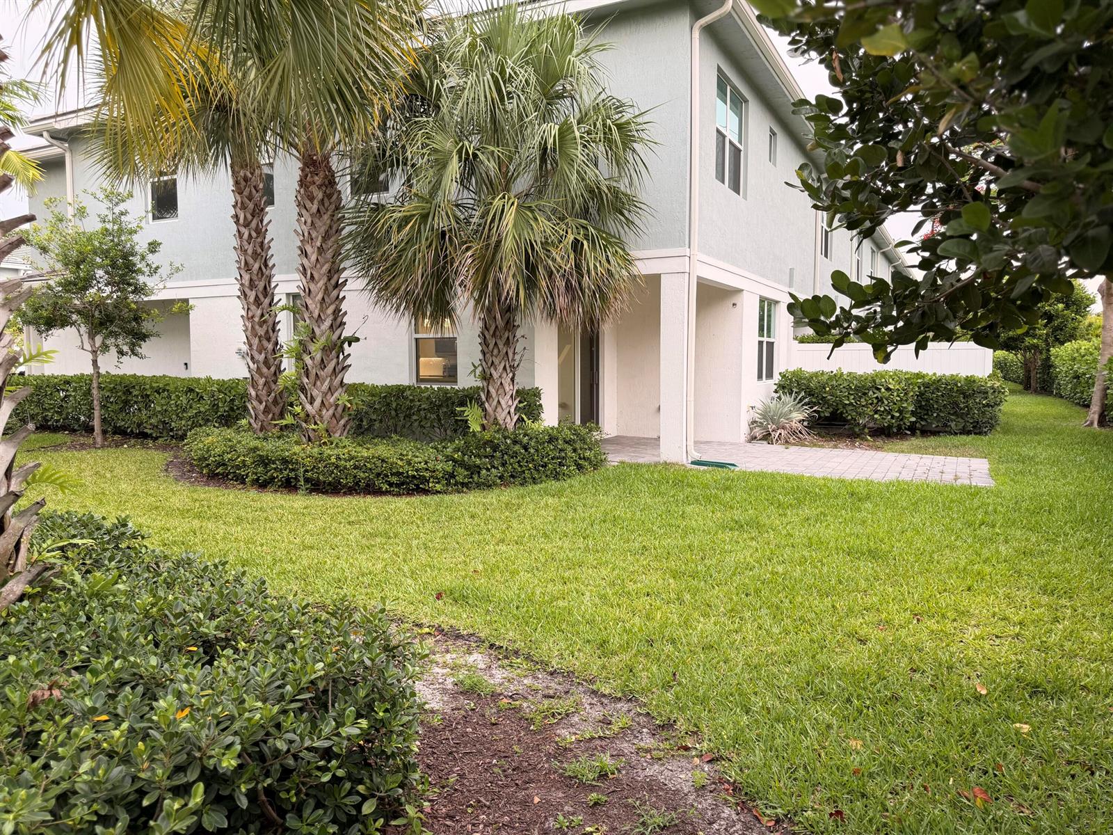 A two-story light green building with palm trees and a paved patio area — 562 Parsons Way, Deerfield Beach FL 33442, DEERFIELD BEACH, FL