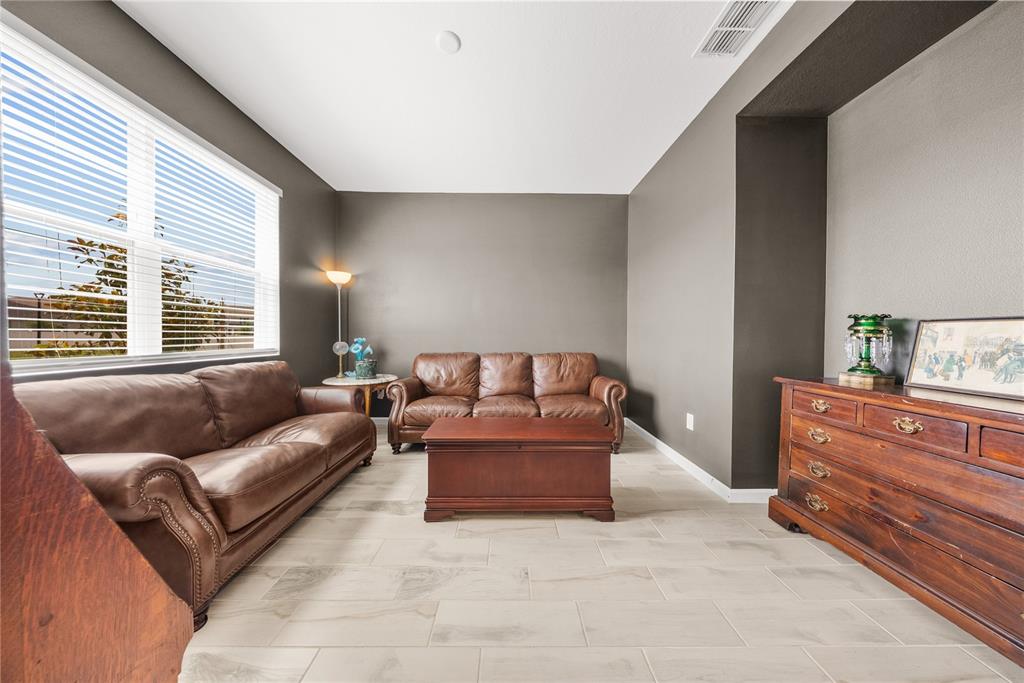 A living room features two brown leather sofas, a wooden coffee table, and tile flooring — 12918 PROMISE PLACE, ORLANDO, FL
