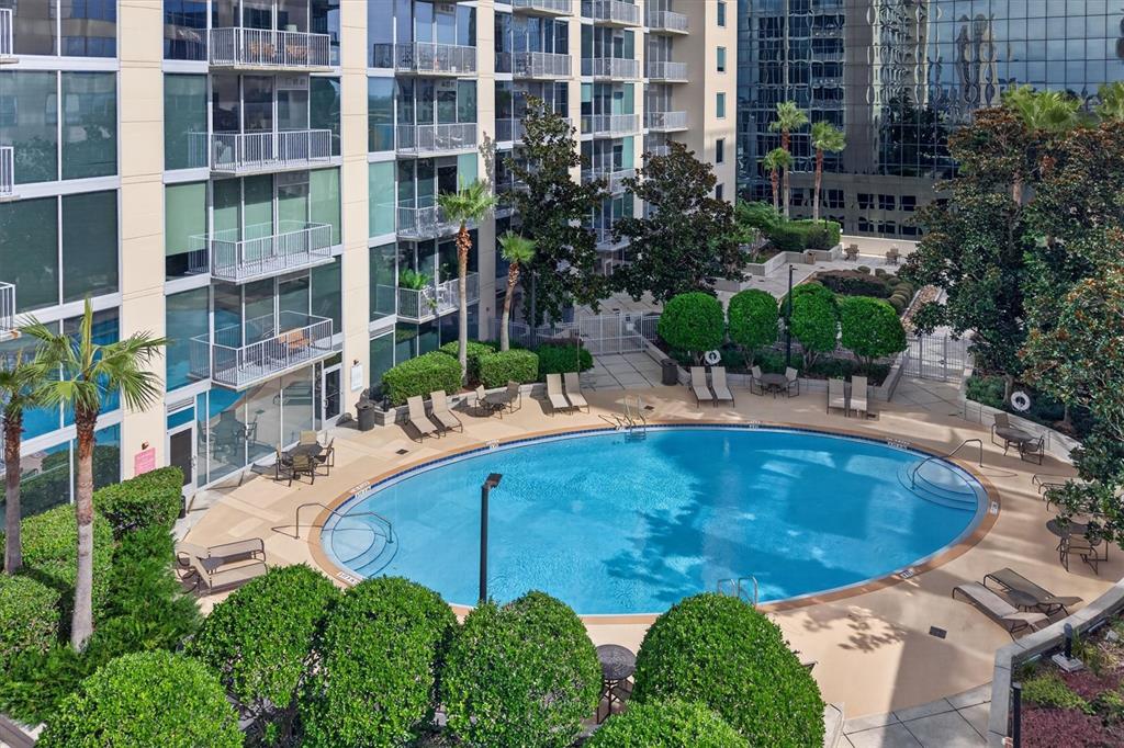 An elevated view of a swimming pool surrounded by lounge chairs and apartment building balconies — 155 S COURT AVENUE UNIT 2514, ORLANDO, FL