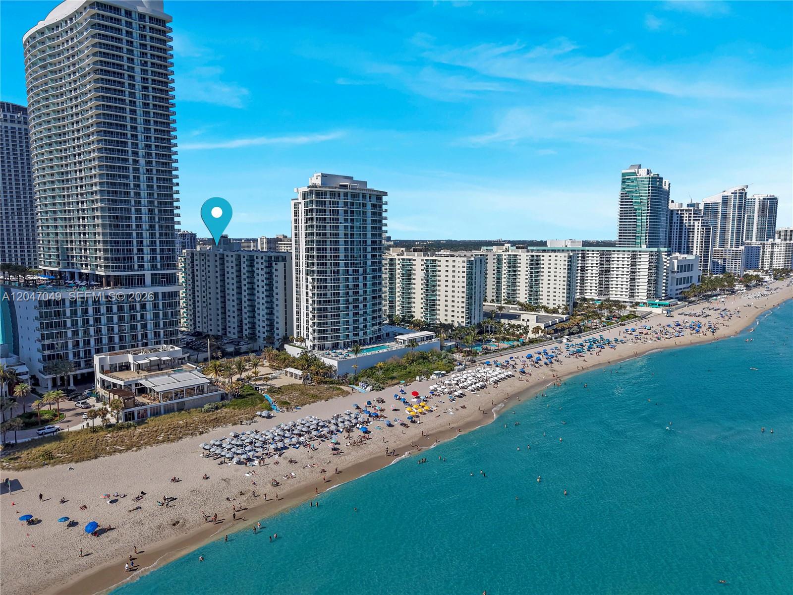 An aerial view shows multiple high-rise residential buildings situated along a sandy beach — 4001 S Ocean Dr # 11M, Hollywood FL 33019, HOLLYWOOD, FL