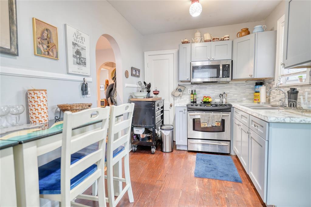 A kitchen features light blue cabinets, stainless steel appliances, and wood flooring — 735 26TH AVENUE S, ST PETERSBURG, FL