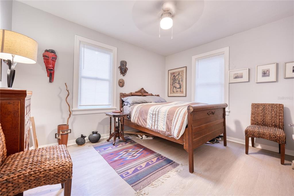 A bedroom features a wooden bed frame, a patterned rug, and wall-mounted decorative masks — 735 26TH AVENUE S, ST PETERSBURG, FL