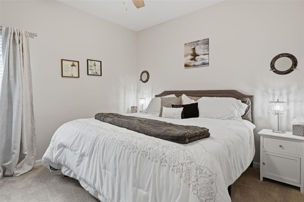A bedroom features a king-sized bed with white bedding, a gray throw, and two nightstands — 500 GRAND LANDINGS PARKWAY, PALM COAST, FL