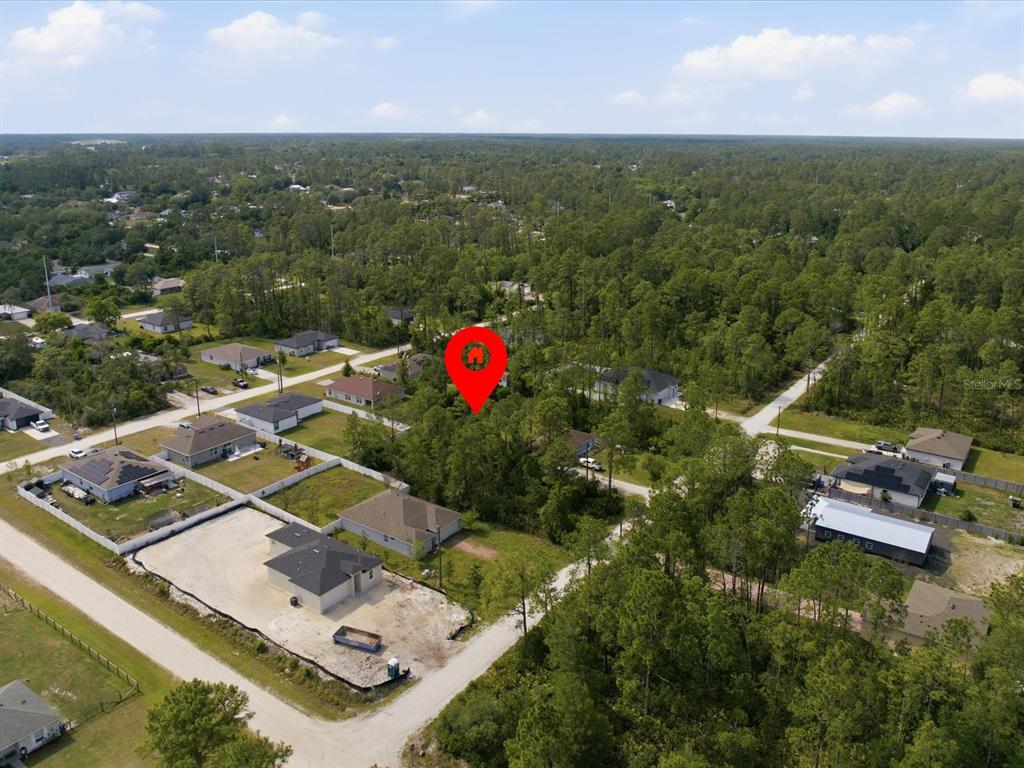 An aerial view shows a wooded residential lot marked with a red pin — 1340 EAST PARKWAY, DELAND, FL