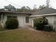 A view of the exterior of a single-story house with a yard and AC unit — 2508 50TH AVENUE N, ST PETERSBURG, FL