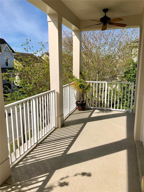A covered balcony features a white railing, a ceiling fan, and a potted palm plant — 4281 ANISSA AVENUE UNIT 11, ORLANDO, FL