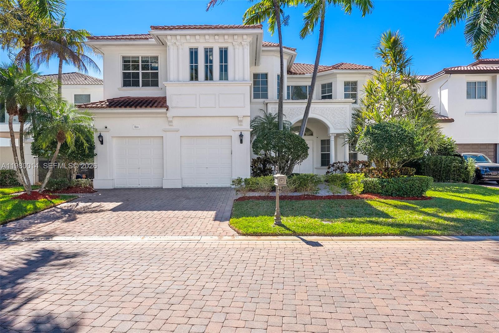 A two-story white stucco house features a two-car garage, tile roof, and landscaped front yard — 822 Meridian Ln, Hollywood FL 33019, HOLLYWOOD, FL