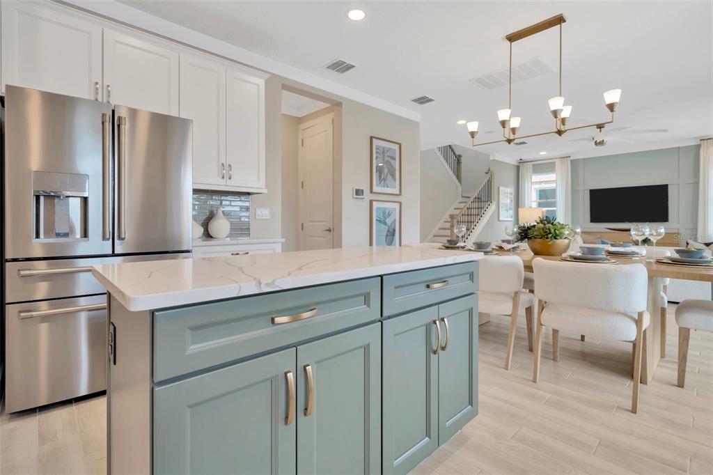 A kitchen island with blue cabinets and a white countertop sits before a dining area — 3892 ROCKY ISLAND ROAD, NEW PORT RICHEY, FL