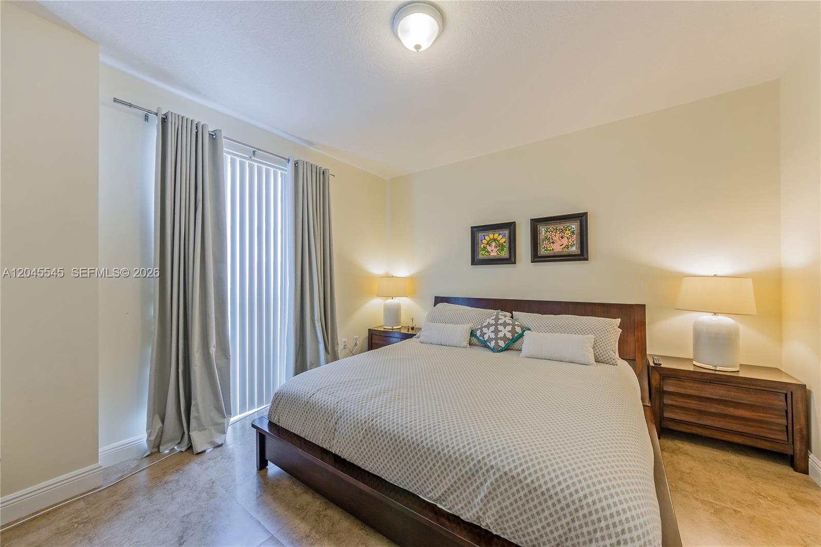 A bedroom features a platform bed, two nightstands with lamps, and floor-to-ceiling curtains — 7285 SW 90th St # D409, Miami FL 33156, MIAMI, FL