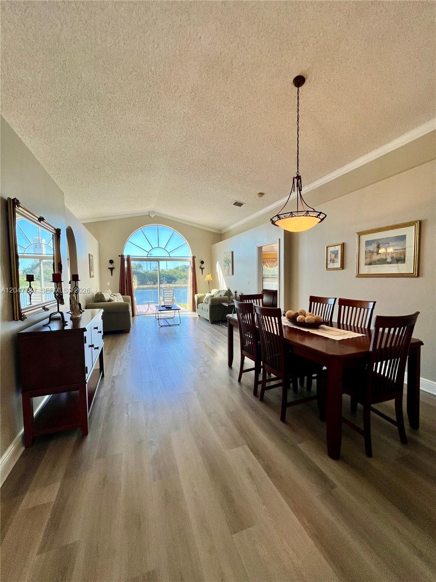 A dining and living area features wood-look flooring, a vaulted ceiling, and a large window — 2754 SW 183rd Ave, Miramar FL 33029, MIRAMAR, FL