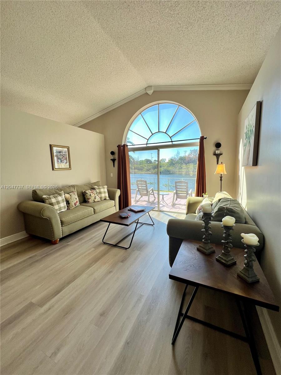 A living room features two sofas, a coffee table, and a large arched window overlooking water — 2754 SW 183rd Ave, Miramar FL 33029, MIRAMAR, FL