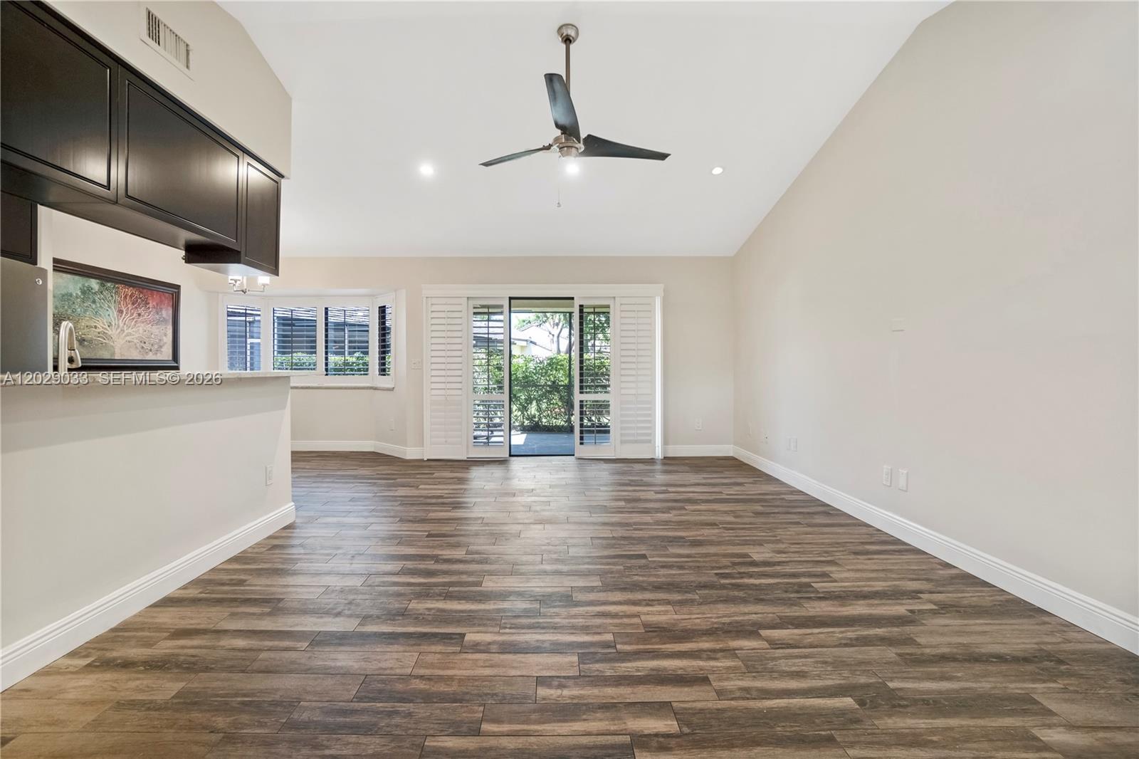 A screened-in patio with a concrete floor overlooks a backyard with hedges and trees — 349 NW 94th Ter, Plantation FL 33324, PLANTATION, FL