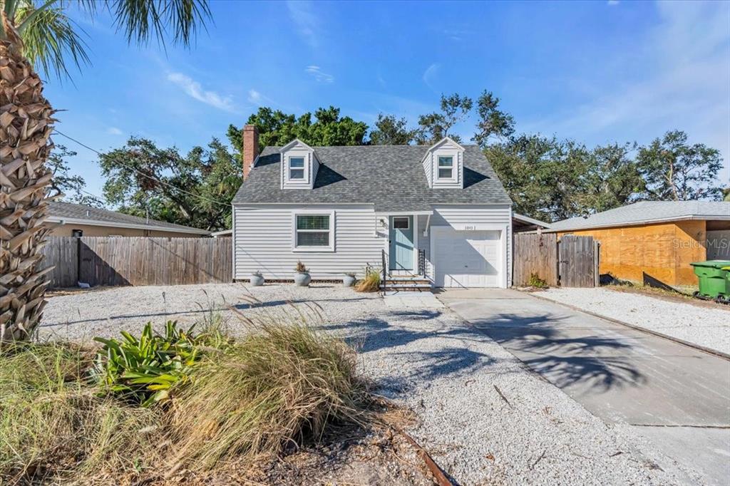 A light gray, two-story house with a gravel front yard and an attached garage — 3843 CHAPEL DRIVE, SARASOTA, FL