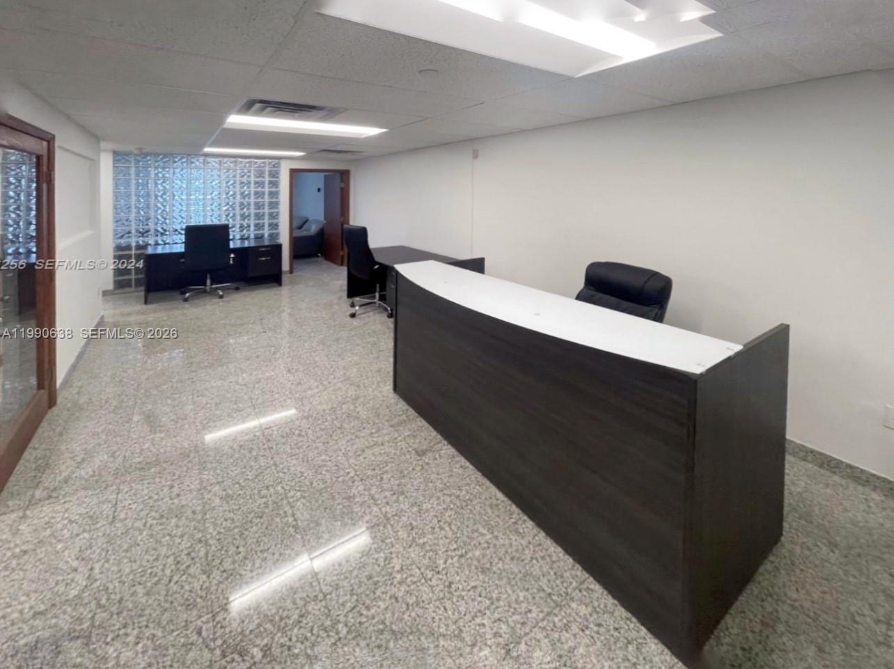 An office space features a reception desk, two workstations, glass block windows, and tile flooring — 4300 Biscayne Blvd # 202, Miami FL 33137, MIAMI, FL