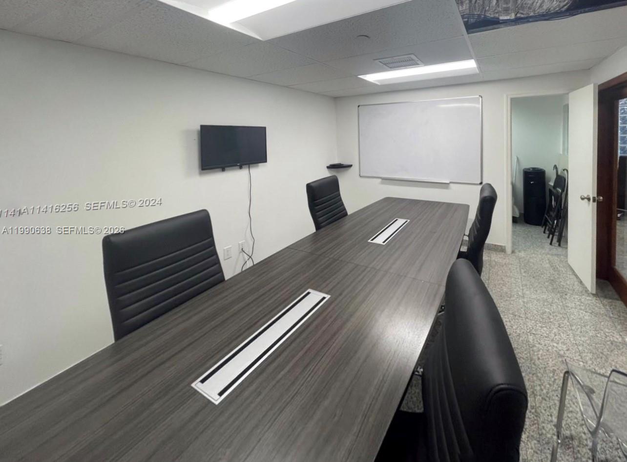 A conference room features a long dark wood table, black chairs, and a whiteboard — 4300 Biscayne Blvd # 202, Miami FL 33137, MIAMI, FL