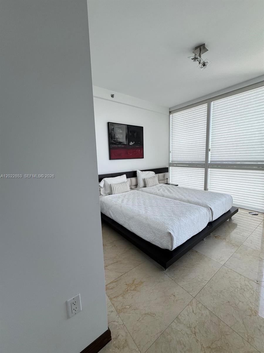 A bedroom features two twin beds on a dark platform frame with tiled flooring — 450 Alton Rd # 3505, Miami Beach FL 33139, MIAMI BEACH, FL