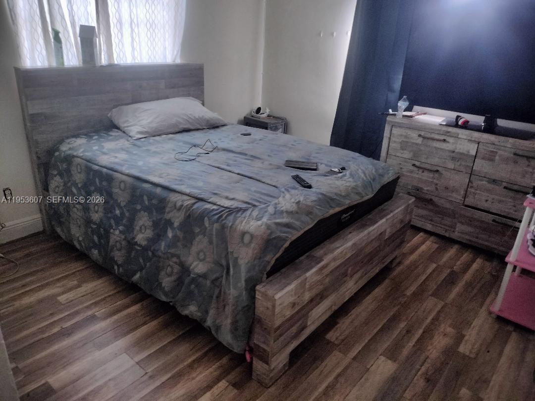 A bedroom features a wooden bed frame, a matching dresser, and wood-look flooring — 3206 SW 47th Ave, West Park FL 33023, WEST PARK, FL