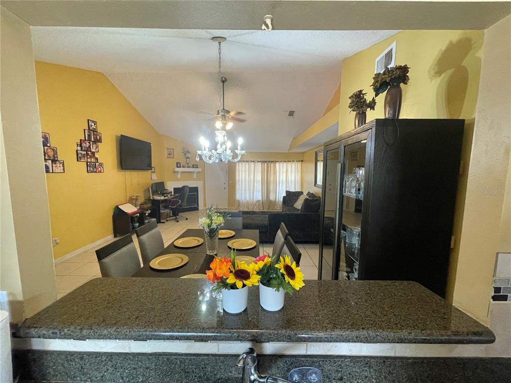 A view from a kitchen counter looking into a dining area and living room — 3050 GOLDEN ROCK DRIVE, ORLANDO, FL