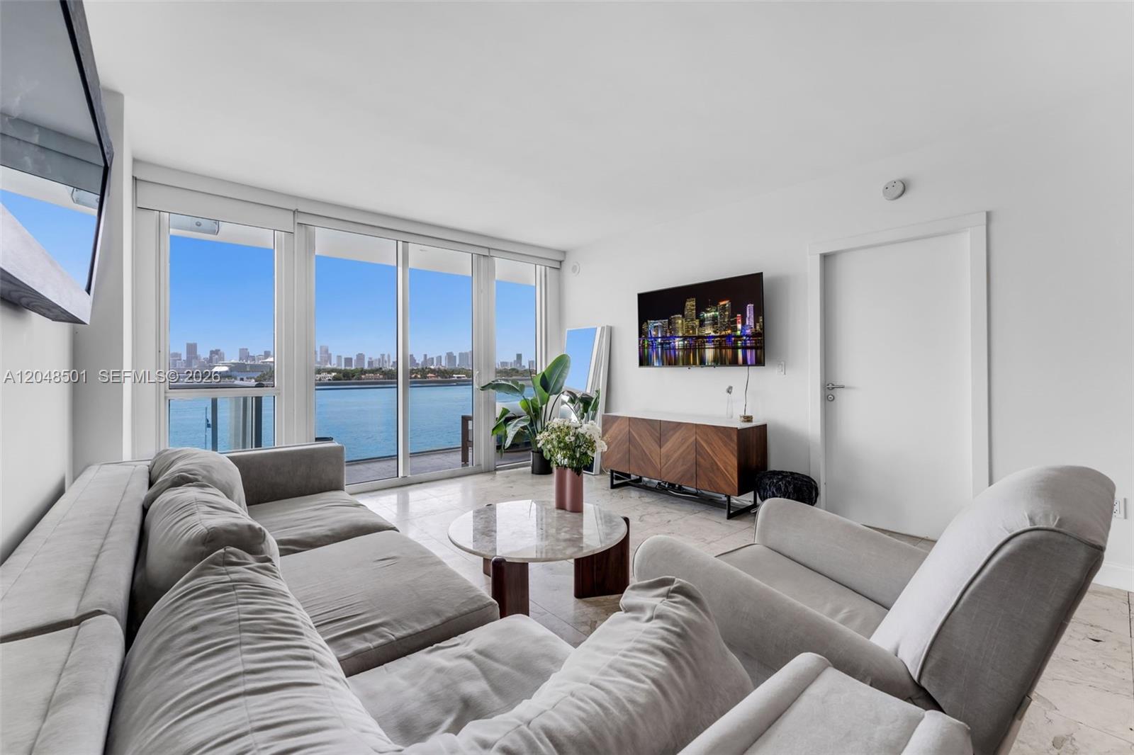 A living room features a grey sofa, a marble coffee table, and floor-to-ceiling windows — 520 West Ave # 604, Miami Beach FL 33139, MIAMI BEACH, FL