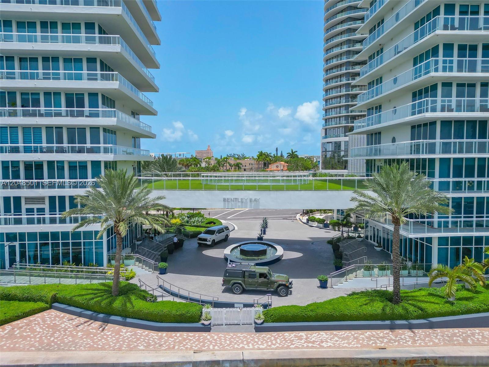 An exterior view of the Bentley Bay residential complex with a central fountain and driveway — 520 West Ave # 604, Miami Beach FL 33139, MIAMI BEACH, FL